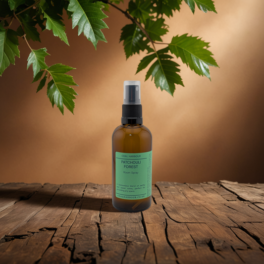 Bottle of Patchouli Forest spray on a wooden surface with green leaves in the background