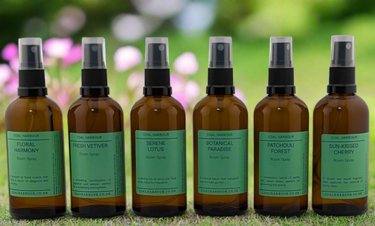 Row of summer fragrance brown spray bottles with green labels on grass