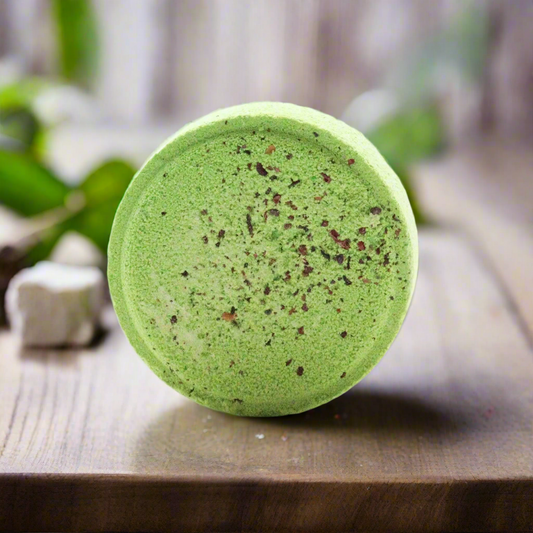 Green bath bomb with speckled texture on a wooden surface