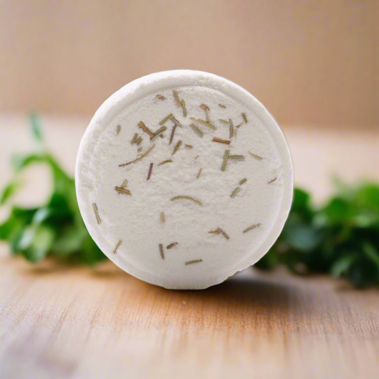 Bath bomb with green herbs on a wooden surface